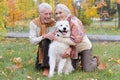 Portrait of happy senior couple in autumn park with dog Royalty Free Stock Photo
