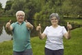Portrait of happy senior couple giving thumbs up after doing sports exercise in nature Royalty Free Stock Photo