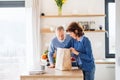 A portrait of senior couple indoors at home, unpacking shopping. Royalty Free Stock Photo