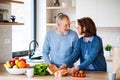 A portrait of senior couple indoors at home, unpacking shopping. Royalty Free Stock Photo