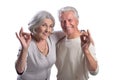 Portrait of happy senior couple showing ok on white background