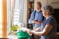 Senior couple using a smartphone while unpacking groceries in the kitchen at home Royalty Free Stock Photo