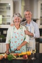 Portrait of happy senior couple standing in kitchen Royalty Free Stock Photo