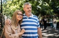 Portrait of happy senior couple standing outdoors in city or town park. Royalty Free Stock Photo