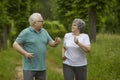 Happy senior man and woman enjoying an active running workout in a green summer park Royalty Free Stock Photo