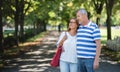 Portrait of happy senior couple walking outdoors in city or town park. Royalty Free Stock Photo