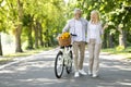 Portrait Of Happy Senior Couple Walking With Retro Bike In City Park Royalty Free Stock Photo