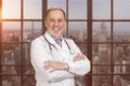 Portrait of happy senior doctor with folded arms. Royalty Free Stock Photo