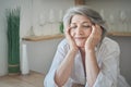 Portrait of a happy senior elderly woman with closed eyes in a bright comfortable apartment. Royalty Free Stock Photo