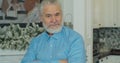 Portrait of happy senior man with gray hair and beard smiling at home. Old man with gray hair and beard and looking at Royalty Free Stock Photo