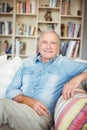 Portrait of happy senior man sitting on sofa Royalty Free Stock Photo