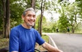 portrait happy senior man in sportswear sitting on bench in the forest park Royalty Free Stock Photo