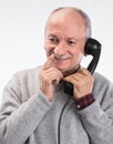 Portrait of happy senior man talking on old landline phone Royalty Free Stock Photo