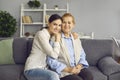 Portrait of happy senior mother together with her grown-up daughter sitting on sofa Royalty Free Stock Photo