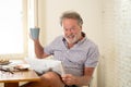 Happy old man reading the newspaper while having breakfast Royalty Free Stock Photo
