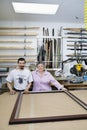 Portrait of happy senior owner with mature employee in frame workshop