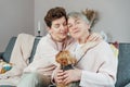 Portrait of happy senior 70s mother, adult neutral gender daughter and Yorkshire terriers dog hugging. Happy family Royalty Free Stock Photo