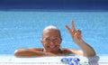 Portrait of an happy senior sporty woman enjoying swimm into the swimming pool doing ok gesture with hand  - active retiree Royalty Free Stock Photo