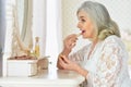 Portrait of happy senior woman applying makeup Royalty Free Stock Photo