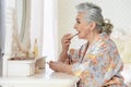 Portrait of happy senior woman applying makeup Royalty Free Stock Photo