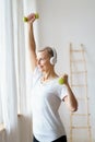 Portrait of happy senior woman doing fitness exercise with dumbbells at home Royalty Free Stock Photo