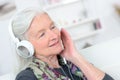 Portrait happy senior woman enjoying music with headphone Royalty Free Stock Photo