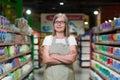 Portrait of happy senior woman grocery store employee with arms crossed smiling and looking at camera Royalty Free Stock Photo