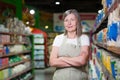 Portrait of happy senior woman grocery store employee with arms crossed smiling and looking at camera Royalty Free Stock Photo