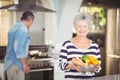 Portrait of happy senior woman holding colander with vegetables Royalty Free Stock Photo