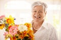 Portrait of happy senior woman holding flowers Royalty Free Stock Photo