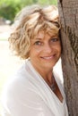 Portrait of a happy senior woman holding tree Royalty Free Stock Photo