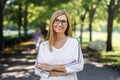 Happy senior woman looking at camera outdoors in city or town park. Royalty Free Stock Photo