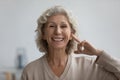 Portrait of happy senior woman pointing finger at her ear Royalty Free Stock Photo