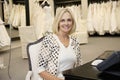 Portrait of a happy senior woman sitting in bridal store