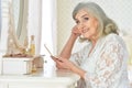 Portrait of happy senior woman sitting near dressing table Royalty Free Stock Photo