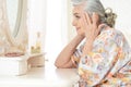 Portrait of happy senior woman sitting near dressing table Royalty Free Stock Photo