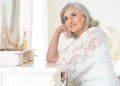 Portrait of happy senior woman sitting near dressing table Royalty Free Stock Photo