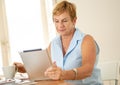 Portrait of a happy senior woman using electronic tablet at home Royalty Free Stock Photo