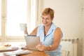 Portrait of a happy senior woman using electronic tablet at home Royalty Free Stock Photo