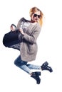 Portrait of happy shopaholic enjoying her shopping she jumping up with shopping bags against the white background