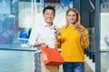 Portrait of happy shoppers asian man and blonde woman smiling and looking at camera, diverse couple in supermarket with Royalty Free Stock Photo