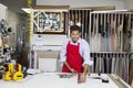 Portrait of a happy skilled worker measuring with meter stick in workshop Royalty Free Stock Photo