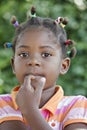 pensive african girl with several colorful ponytails