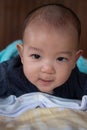 Portrait of happy small Asian infant baby. Kid is lying, smiling, playing on the bed