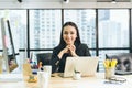 Portrait of happy smile young asian business women sitting at her desks in the office looking camera Royalty Free Stock Photo