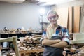 portrait of happy smile young carpenter woman wearing goggles arms crossed professional handyman. carpenter workshop furniture Royalty Free Stock Photo