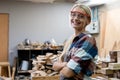 portrait of happy smile young carpenter woman wearing goggles arms crossed professional handyman. carpenter workshop furniture Royalty Free Stock Photo