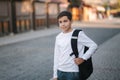 Portrait of happy smiled teenage boy in white sweatshirt with backpack outside Royalty Free Stock Photo