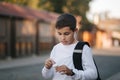 Portrait of happy smiled teenage boy in white sweatshirt with backpack outside Royalty Free Stock Photo