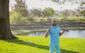 Portrait of happy smilin golfer hitting golf shot with club on course.